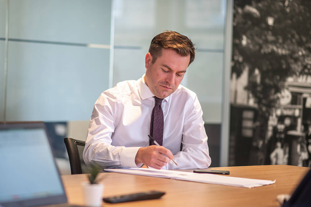 man writing in boardroom