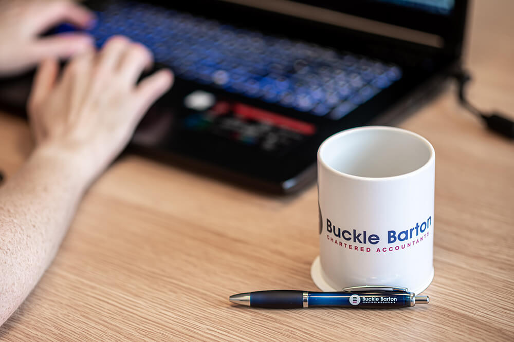 mug and pen near a keyboard