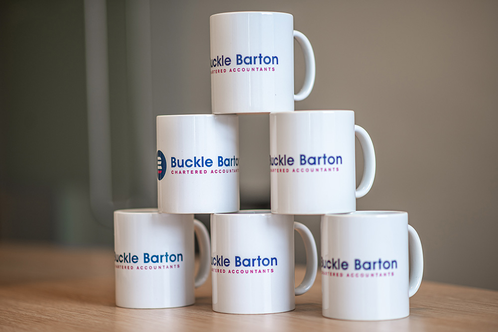 stack of branded white mugs