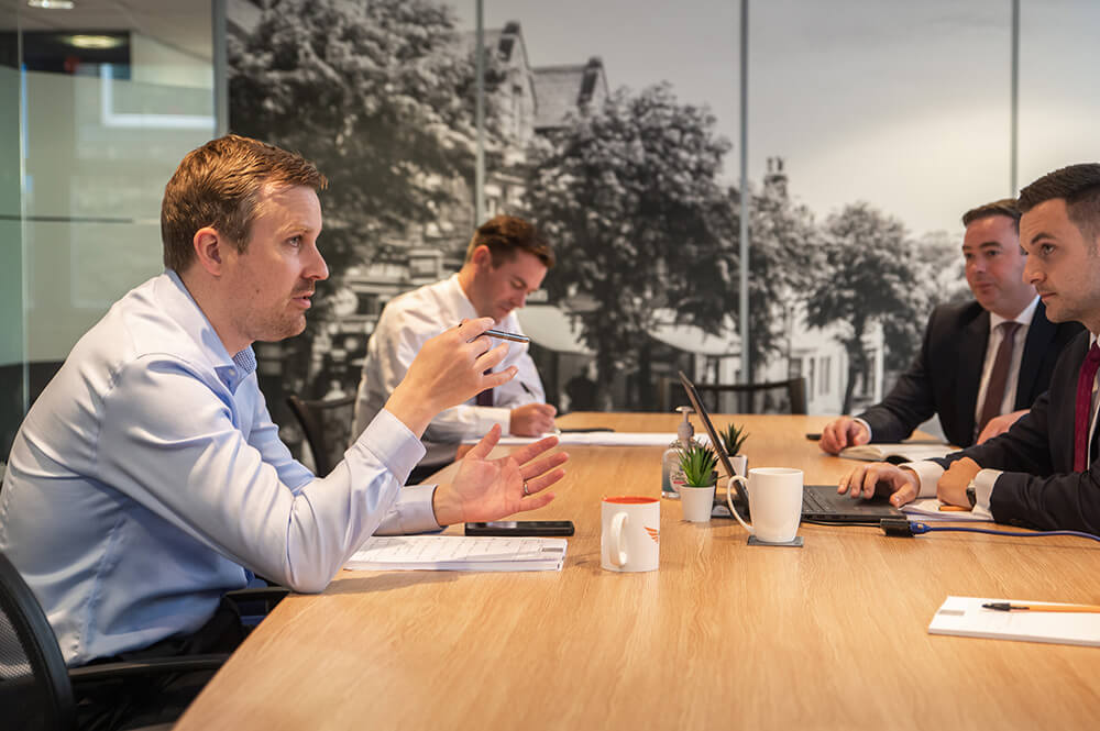 four men at a boardroom table